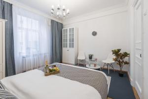 ein weißes Schlafzimmer mit einem Bett und einem Fenster in der Unterkunft GMApartments Tverskaya street in Moskau