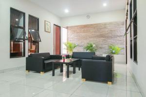a living room with couches and a table and chairs at RedDoorz Syariah near Universitas Jenderal Soedirman in Purwokerto