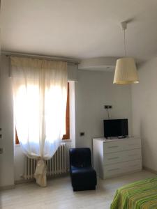 a bedroom with a bed and a chair and a window at CASA ROSI trequattrozerotrentatretrediciseiquattrouno in Umbertide