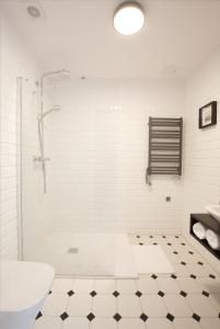 a white bathroom with a shower and a sink at Villa Orla in Gdynia
