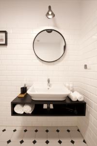a white bathroom with a sink and a mirror at Villa Orla in Gdynia
