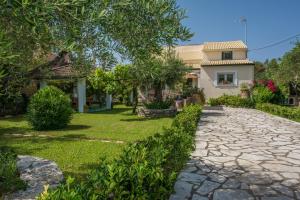 a house with a stone walkway in front of a yard at Corfu Villa Linea in Línia