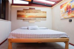 1 cama en una habitación con un cuadro en la pared en MODERNA CASA INDEPENDIENTE CON PISCINA, VISTA MAR Y TEIDE EN LA LISTADA, en La Listada