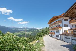 a house on a hill with mountains in the background at Forchnerhof-App Rienzschlucht in Rodengo