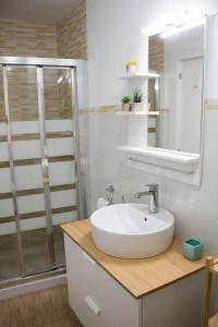 y baño blanco con lavabo y ducha. en Apartamento Reyes Catolicos en Almería