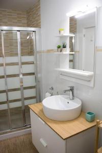 a white bathroom with a sink and a shower at Apartamento Reyes Catolicos in Almería