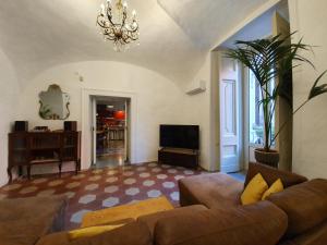 a living room with a couch and a television at The Spanish Palace Rooms, Suites Apartments & Terraces in Naples