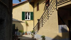 ein Gebäude mit einem grünen Fenster und einer Treppe in der Unterkunft La corte di Quiliano in Quiliano