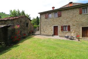 a stone house with a yard in front of it at Casa Ciabatti in Castel Focognano