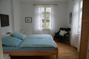 a bedroom with a bed and a chair and a window at Altes Landhaus am Park in Xanten