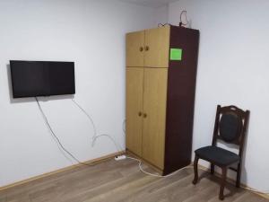 a room with a tv and a chair and a cabinet at Apartmani LazaDora in Boljevac