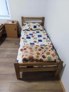 a bed with a quilt on it in a room at Apartmani LazaDora in Boljevac