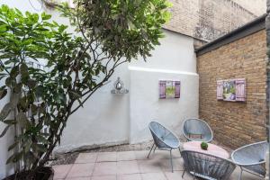 a patio with chairs and a table and a tree at Central London Apartment - Great Location in London