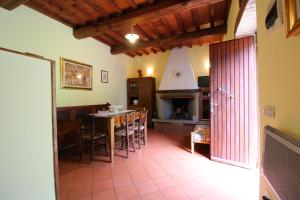 ein Wohnzimmer mit einem Tisch, Stühlen und einem Kamin in der Unterkunft Casa Ciabatti in Castel Focognano