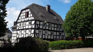 a black and white building with a black roof at Pilgrims Gästeapartements in Meschede