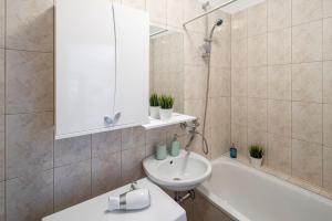 a bathroom with a sink and a bath tub with a mirror at Riga Old Town Souvenir Apartment in Rīga