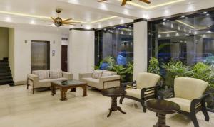 a lobby with chairs and tables and a ceiling fan at Treebo Tryst The Crystal in Kolkata
