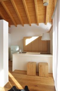 a kitchen with a white counter and wooden ceilings at Loft7 in Mittelberg