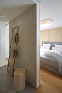 1 dormitorio con cama, escalera y mesa en Loft7, en Mittelberg
