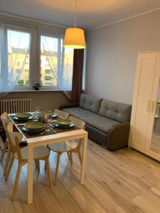 un soggiorno con un tavolo e un divano di Seaside apart Gdynia a Gdynia