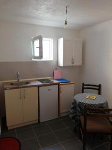 een keuken met witte kasten en een tafel en een tafel en een wastafel bij Sara apartments in Budva