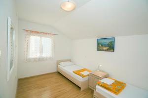 a bedroom with a bed and a table and a window at Apartments Villa Dina in Karlobag +104 photos