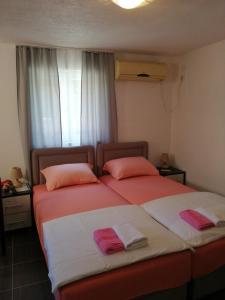 twee bedden naast elkaar in een slaapkamer bij Sara apartments in Budva