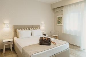 a bedroom with a large bed with a purse on it at Ammos Beach Seaside Luxury Suites Hotel in Olympic Beach +37 photos