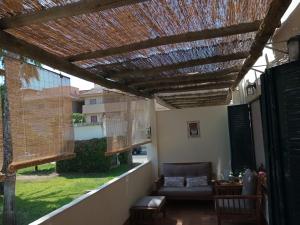a patio with a wooden pergola and a couch at El Cantil in Isla Cristina