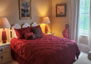 a bedroom with a red bed with two lamps and a window at Harrington House Picton in Picton