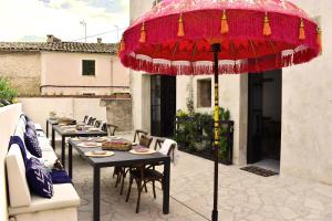 a patio with tables and chairs and a red umbrella at Ten Mallorca - Adults Only in Sineu