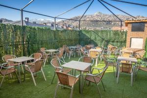 un montón de mesas y sillas sentadas en la hierba en Hostel La Pedriza, en Manzanares el Real