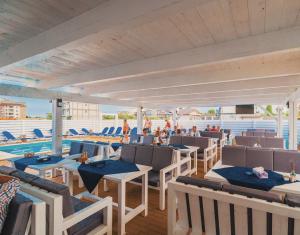 a row of tables and chairs on a patio at Lavender Villa in Mamaia Nord
