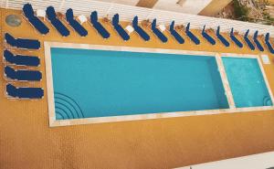 a swimming pool with blue water and blue chairs at Lavender Villa in Mamaia Sat/Năvodari