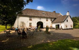 un groupe de personnes assises devant un bâtiment blanc dans l'établissement Fletcher Hotel-Restaurant Kasteel Erenstein, à Kerkrade