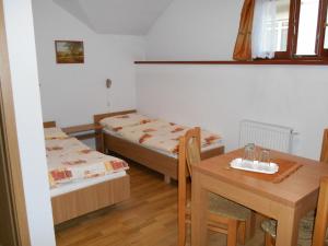 a small room with two beds and a table at Penzión Pars in Žilina
