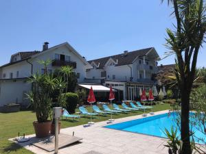 a resort with a pool and chairs and a building at Superior-Apartment mit Pool und Seezugang in Velden am Wörthersee