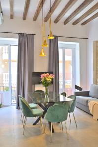 een woonkamer met een glazen tafel en groene stoelen bij MyFlats Luxury Downtown in Alicante