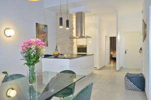 a kitchen with a glass table with a vase of flowers at MyFlats Luxury Downtown in Alicante