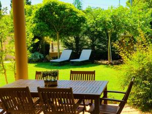 ネア・カリクラティアにあるKtima Anatoli Luxury Resort Residencesの庭の木製テーブルと椅子