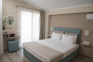 Кровать или кровати в номере Ammos Beach Seaside Luxury Suites Hotel