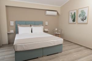 Кровать или кровати в номере Ammos Beach Seaside Luxury Suites Hotel