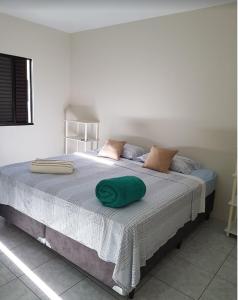 a bed with a green pillow on top of it at CONFORTO e SEGURANÇA AP11 in Guaratuba