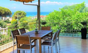 ネア・カリクラティアにあるKtima Anatoli Luxury Resort Residencesの木製テーブルと椅子付きのバルコニー