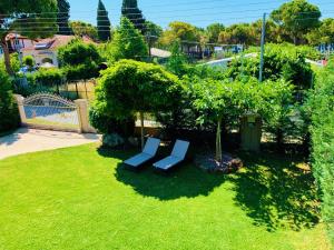 ネア・カリクラティアにあるKtima Anatoli Luxury Resort Residencesの庭の芝生に座る二つのベンチ