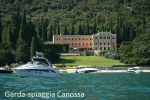 a boat in the water in front of a building at Garda Sailor’s House in Garda