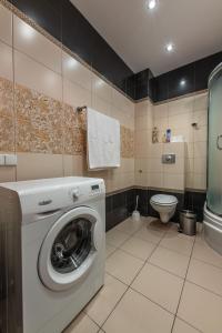 a bathroom with a washing machine and a toilet at Victus Apartamenty, Apartament Walor in Sopot