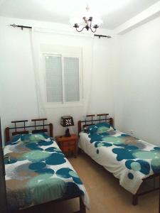 una camera da letto con due letti e una finestra di chic appart vue sur piscine a Tangeri