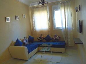 un soggiorno con un divano e una finestra di chic appart vue sur piscine a Tangeri