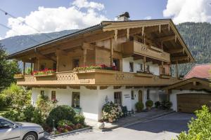 una casa grande con balcones y flores. en Landhaus Johannes, en Mayrhofen